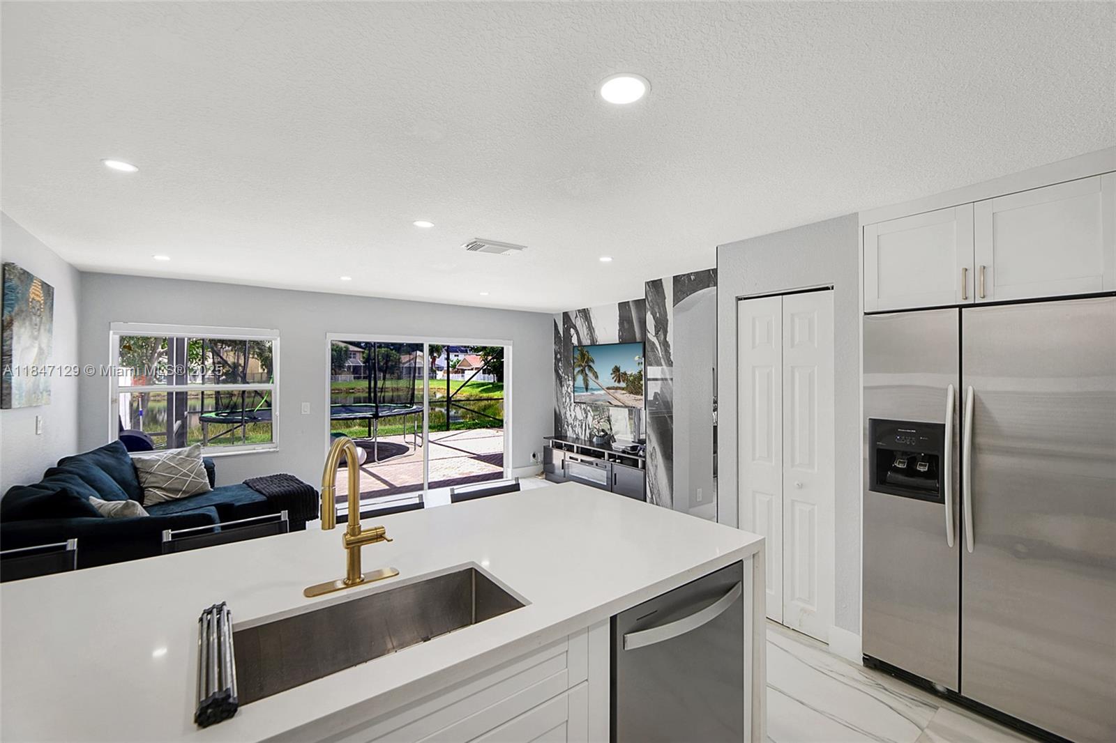 6073 Spring Isles Boulevard Lake Worth, FL 33463 - Photo 19 of 51 a kitchen with a refrigerator a sink and a large window