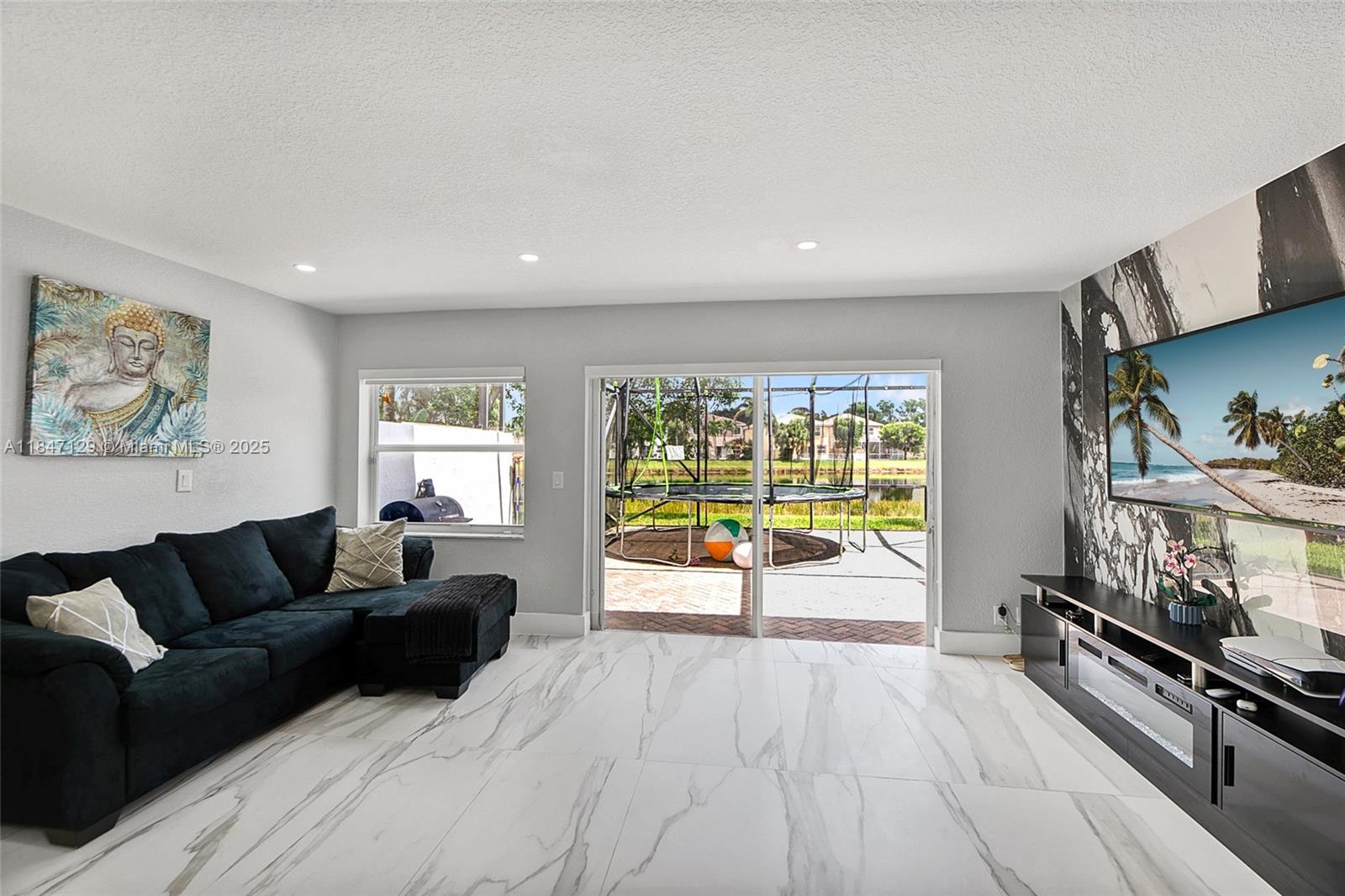 6073 Spring Isles Boulevard Lake Worth, FL 33463 - Photo 20 of 51 a living room with furniture and a flat screen tv