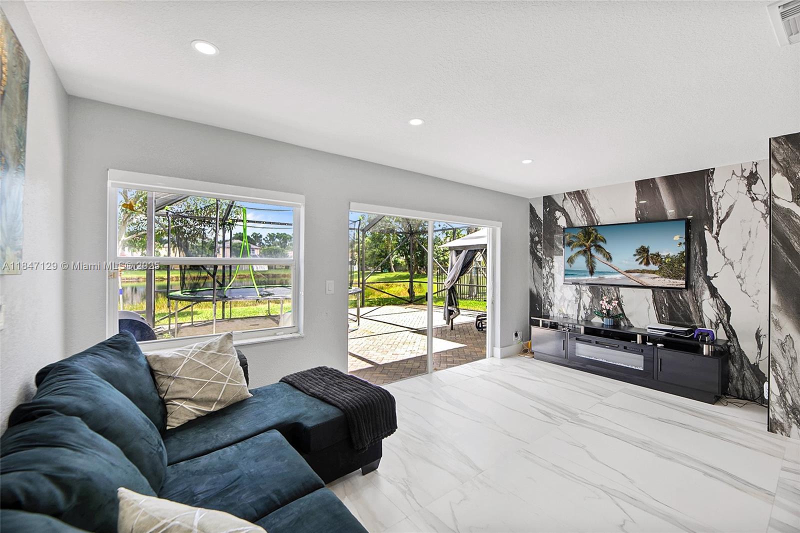 6073 Spring Isles Boulevard Lake Worth, FL 33463 - Photo 21 of 51 a living room with furniture and a flat screen tv