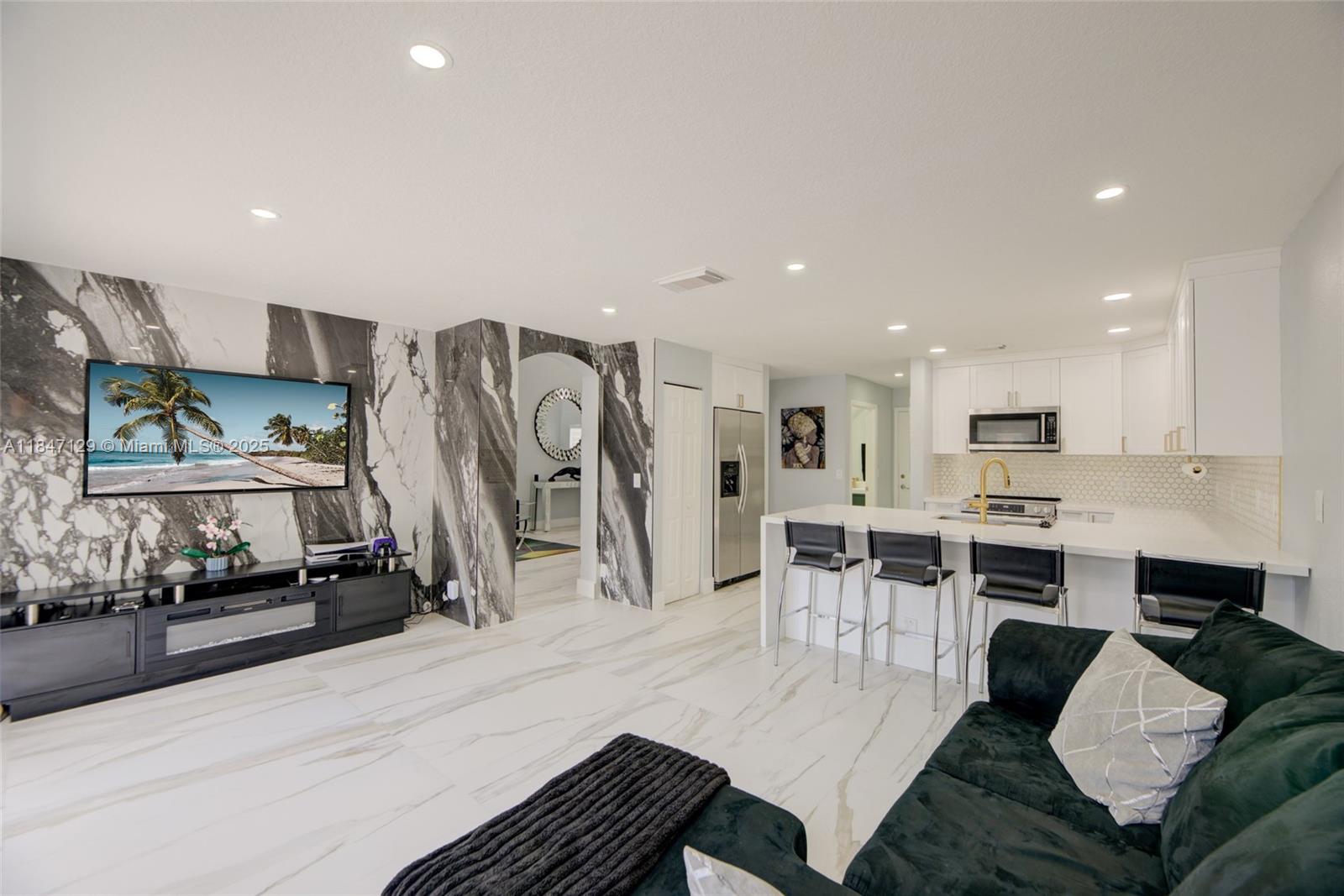 6073 Spring Isles Boulevard Lake Worth, FL 33463 - Photo 22 of 51 a living room with stainless steel appliances kitchen island granite countertop furniture and a view of kitchen