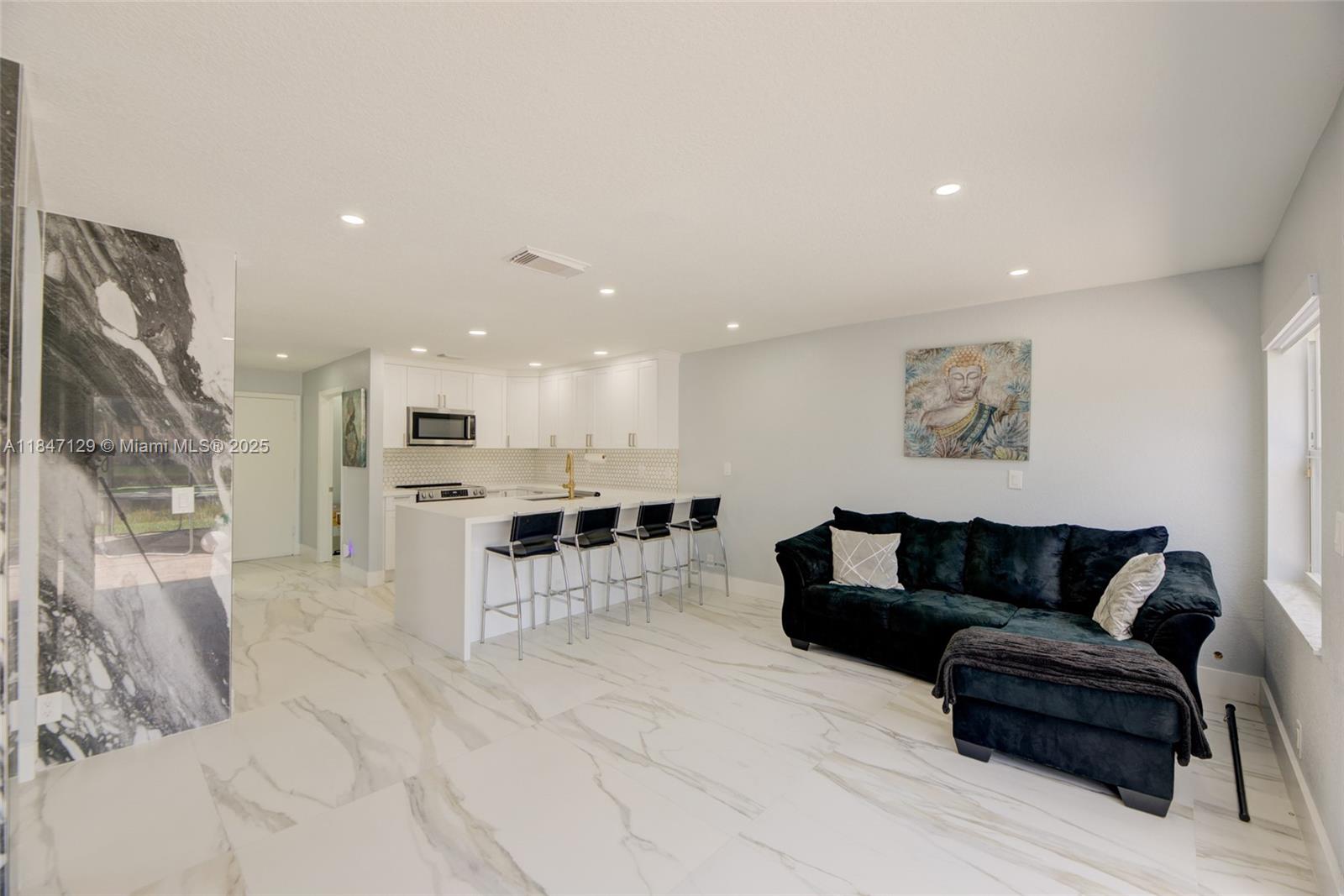 6073 Spring Isles Boulevard Lake Worth, FL 33463 - Photo 23 of 51 a living room with furniture and kitchen view