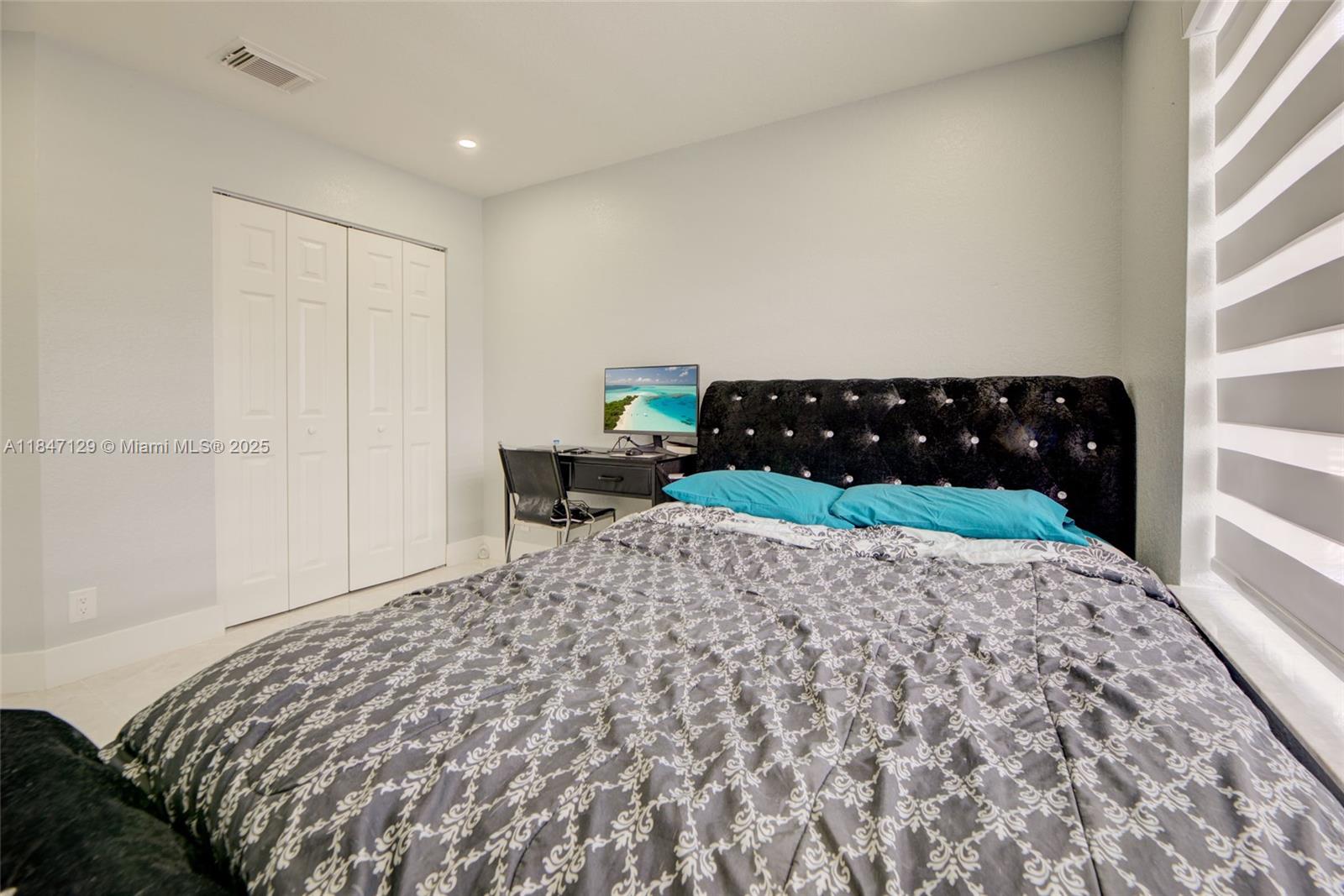 6073 Spring Isles Boulevard Lake Worth, FL 33463 - Photo 38 of 51 a bed sitting in a bedroom next to a window and dresser