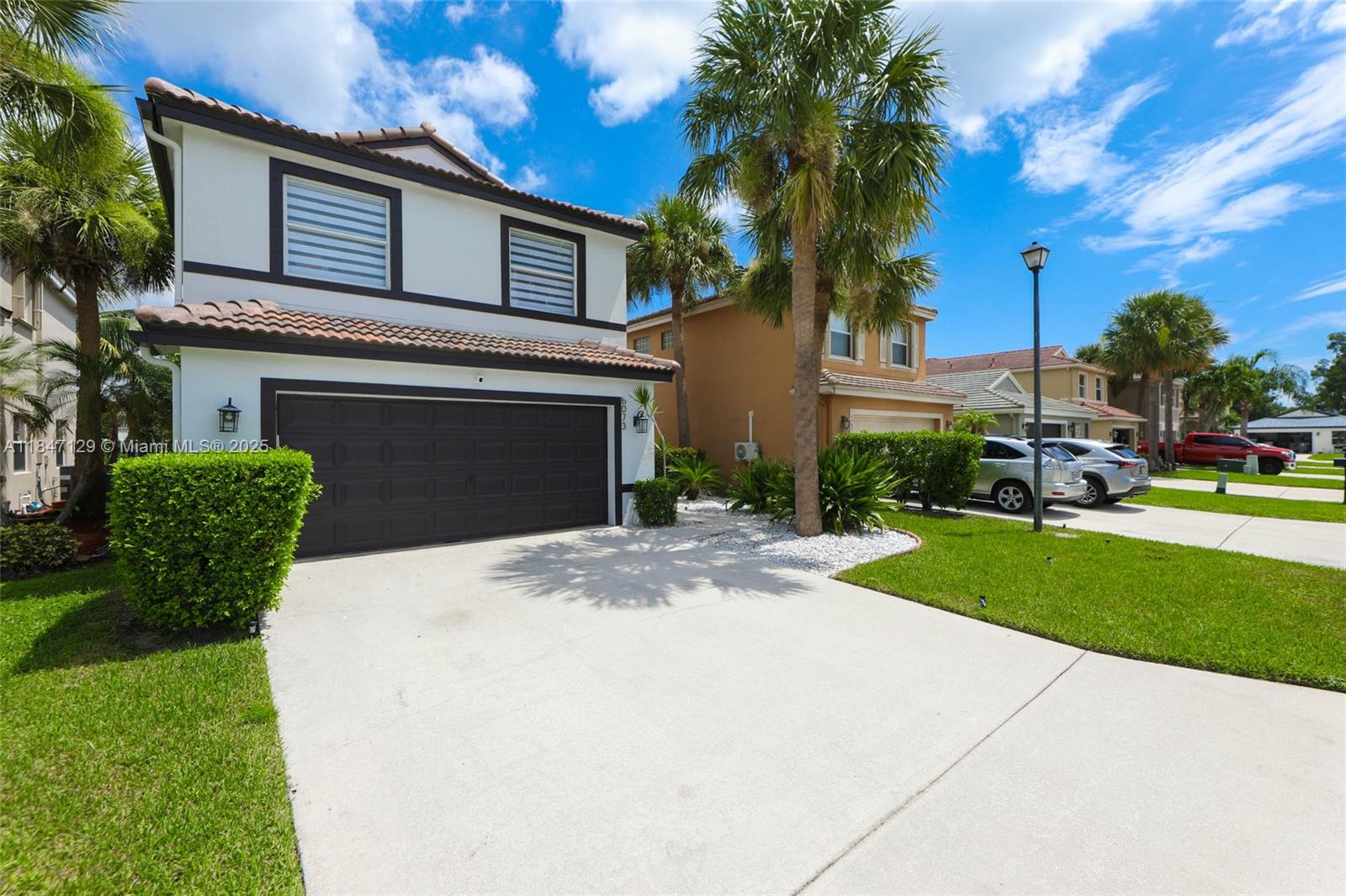 6073 Spring Isles Boulevard Lake Worth, FL 33463 - Photo 4 of 51 a view of a house with a yard and palm trees