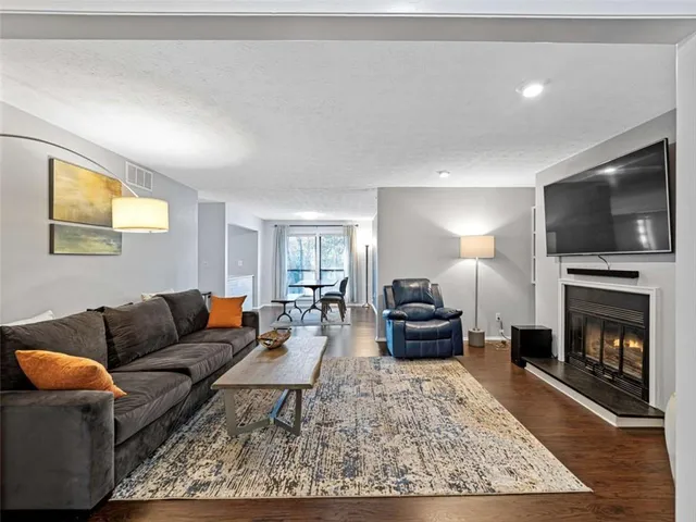 a living room with furniture a flat screen tv and a fireplace