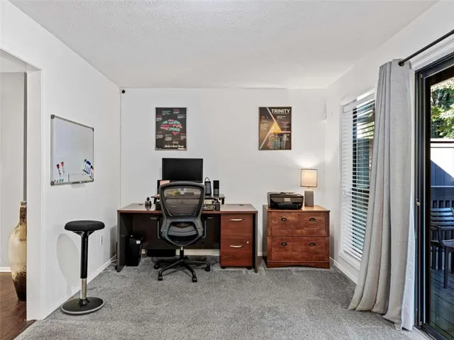 a view of a workspace with furniture and a window