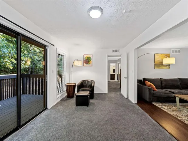 a living room with furniture and a floor to ceiling window
