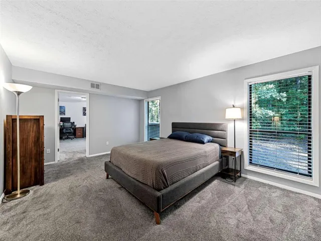 a spacious bedroom with a bed closet and a large window