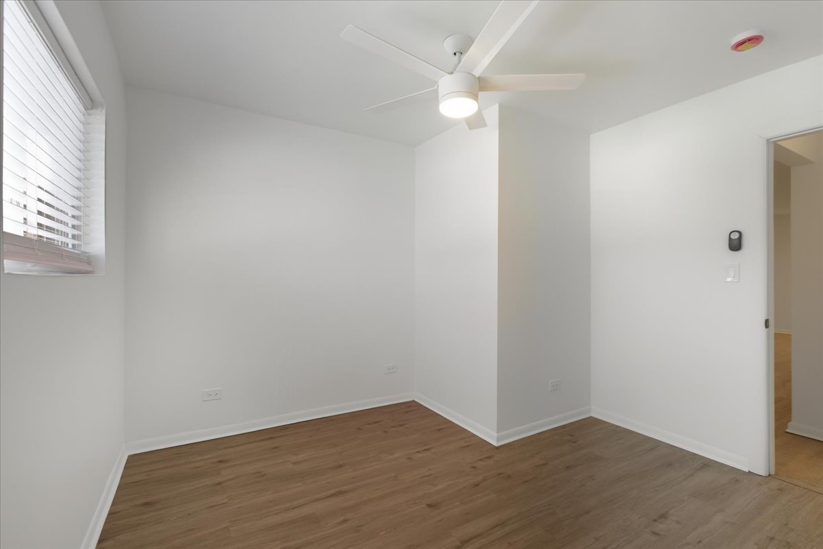 7357 North Winchester Avenue, Unit 2R Chicago, IL 60626 - Photo 7 of 10 an empty room with wooden floor and windows