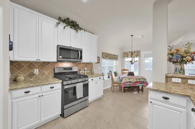 a bedroom with a bed a chandelier and a window
