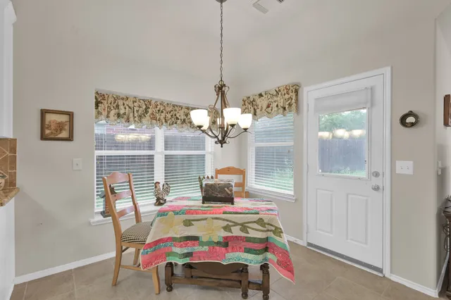 a spacious bedroom with a bed a chair and piano