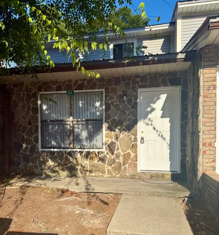 a front view of a house with a tree