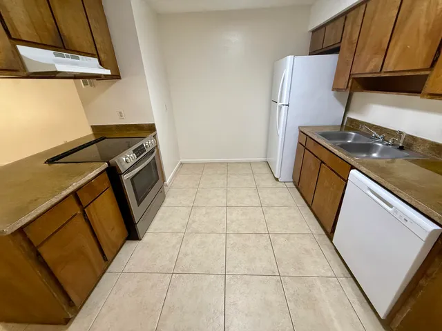 a kitchen with a stove top oven and cabinets