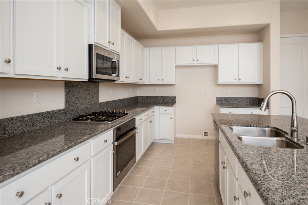 158 Spectacle Irvine, CA 92618 - Photo 4 of 19 a kitchen with granite countertop white cabinets and stainless steel appliances