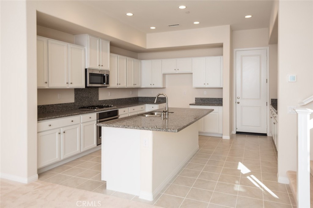 158 Spectacle Irvine, CA 92618 - Photo 6 of 19 a large kitchen with stainless steel appliances granite countertop a sink and a stove