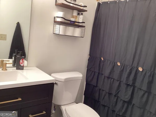 a white toilet sitting next to a bathroom sink