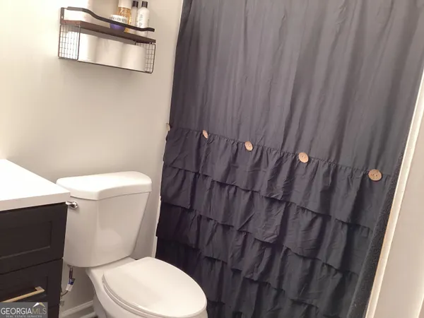 a white toilet sitting next to a shower