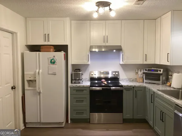 a kitchen with stainless steel appliances granite countertop a stove a refrigerator and a sink