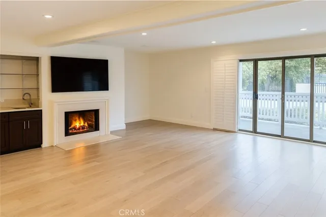 a view of an empty room with a fireplace and a window
