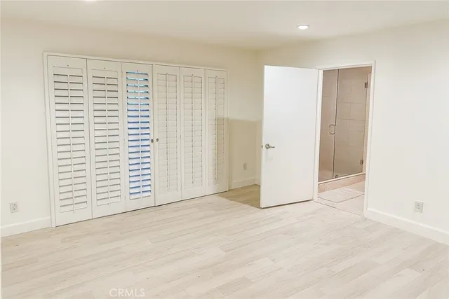 an empty room with wooden floor and white walls