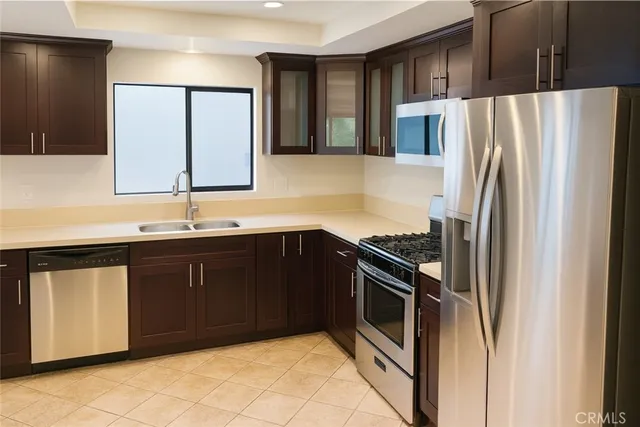 a kitchen with stainless steel appliances granite countertop a refrigerator and a sink