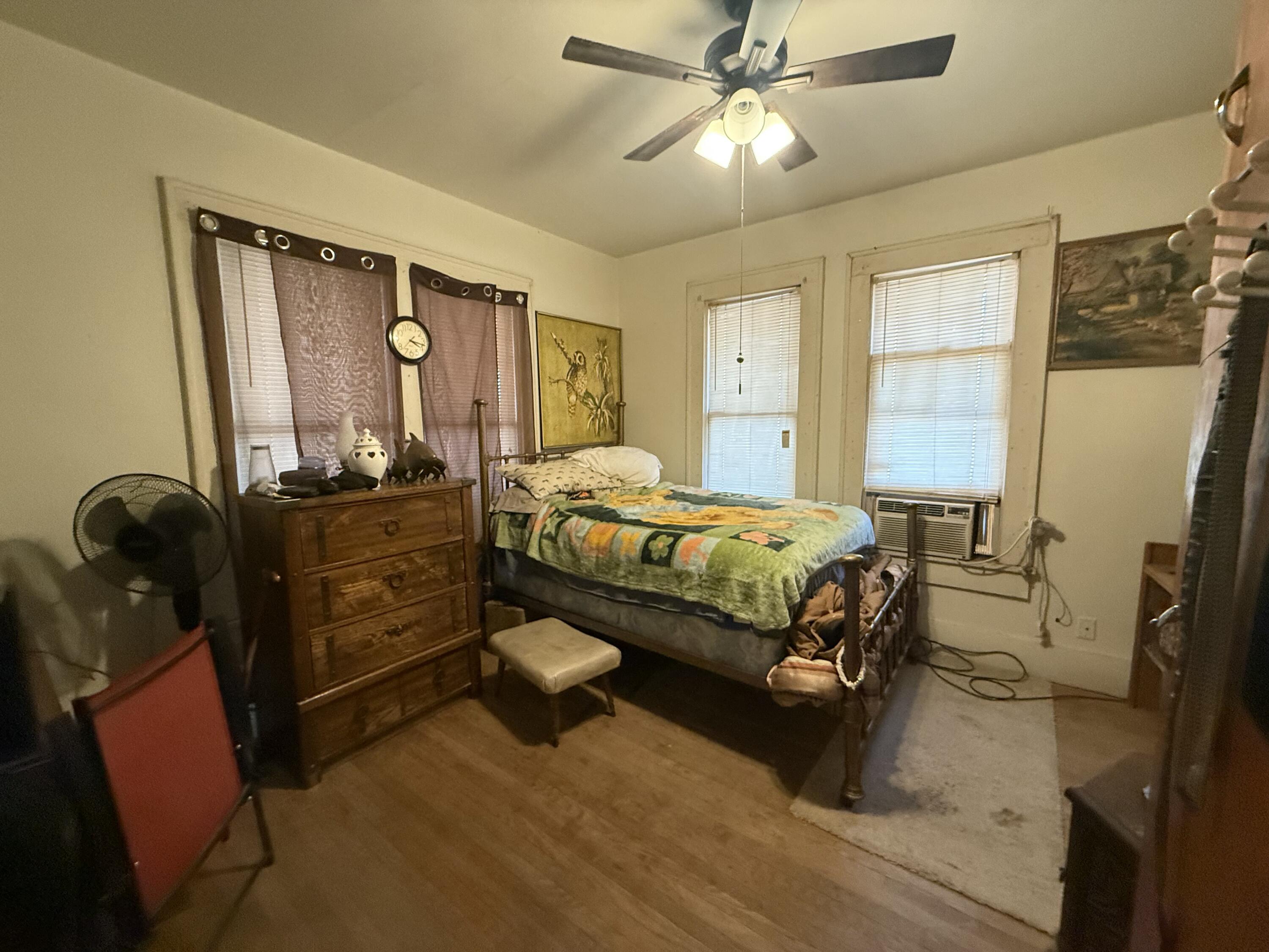 Package Package Property Lubbock, TX 79411 - Photo 43 of 107 a bedroom with a bed dresser and wooden floor