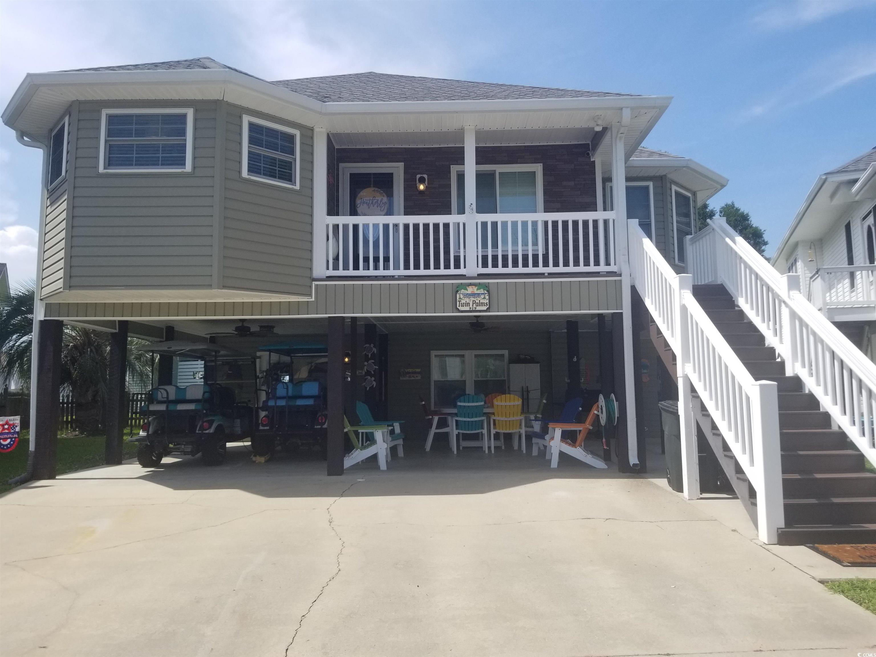 View of front facade with concrete driveway, stairs, a shingled roof, and a carport