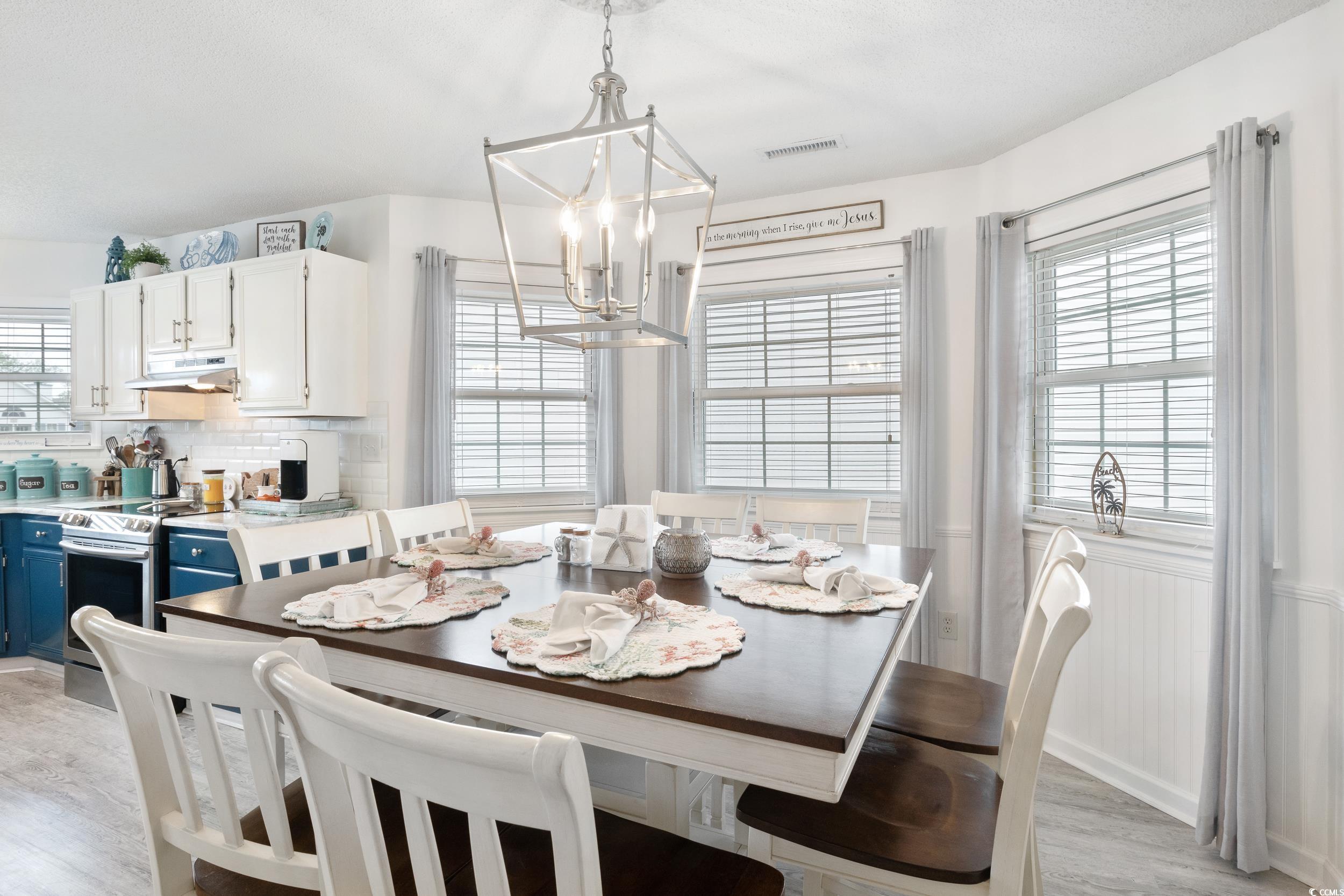 919 Dock Place Murrells Inlet, SC 29576 - Photo 11 of 39 Dining room with a chandelier, light wood-type flooring, and a wainscoted wall