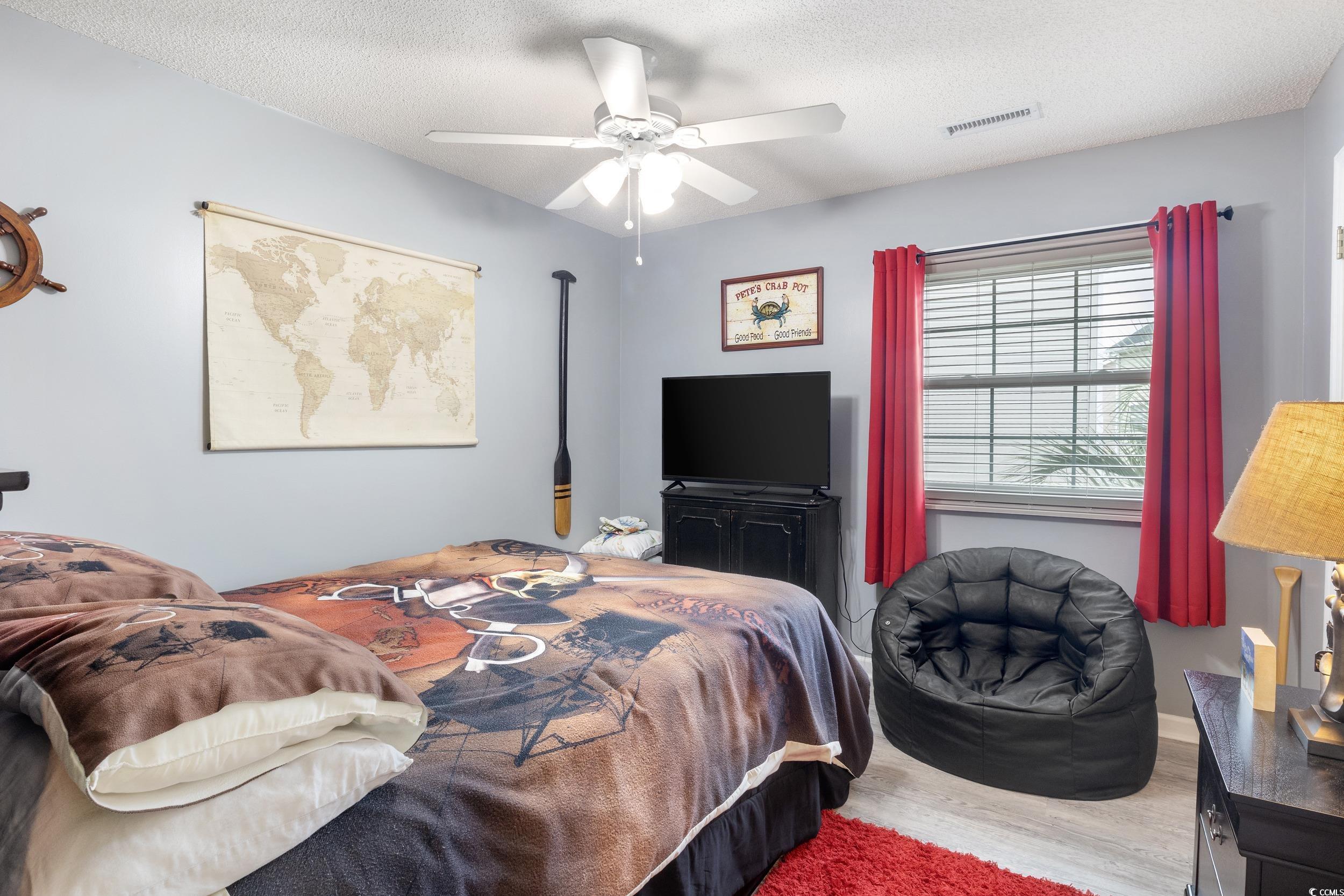 919 Dock Place Murrells Inlet, SC 29576 - Photo 20 of 39 Bedroom with wood finished floors, ceiling fan, and a textured ceiling