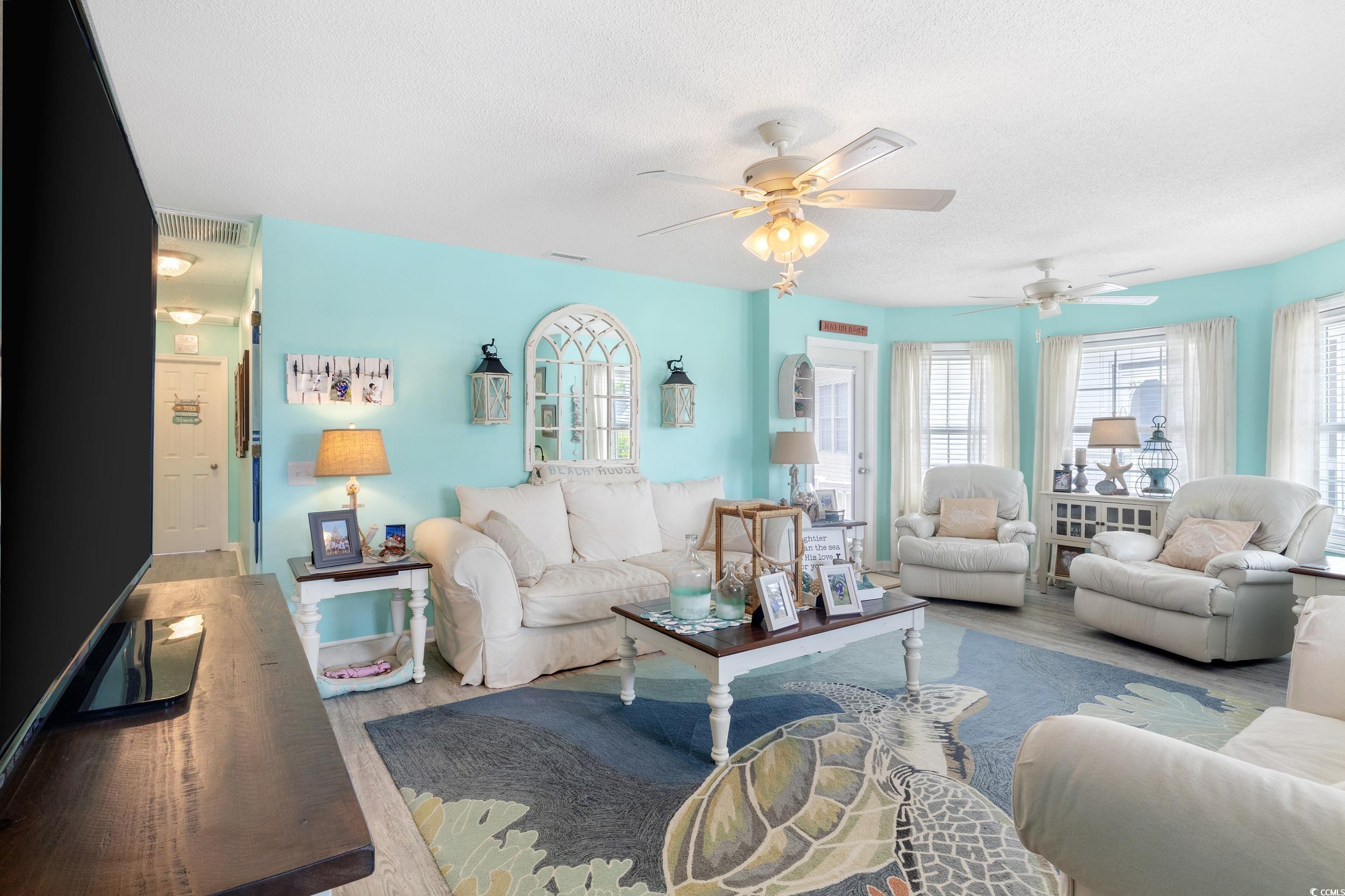 919 Dock Place Murrells Inlet, SC 29576 - Photo 6 of 39 Living room featuring wood finished floors, a ceiling fan, healthy amount of natural light, and a textured ceiling