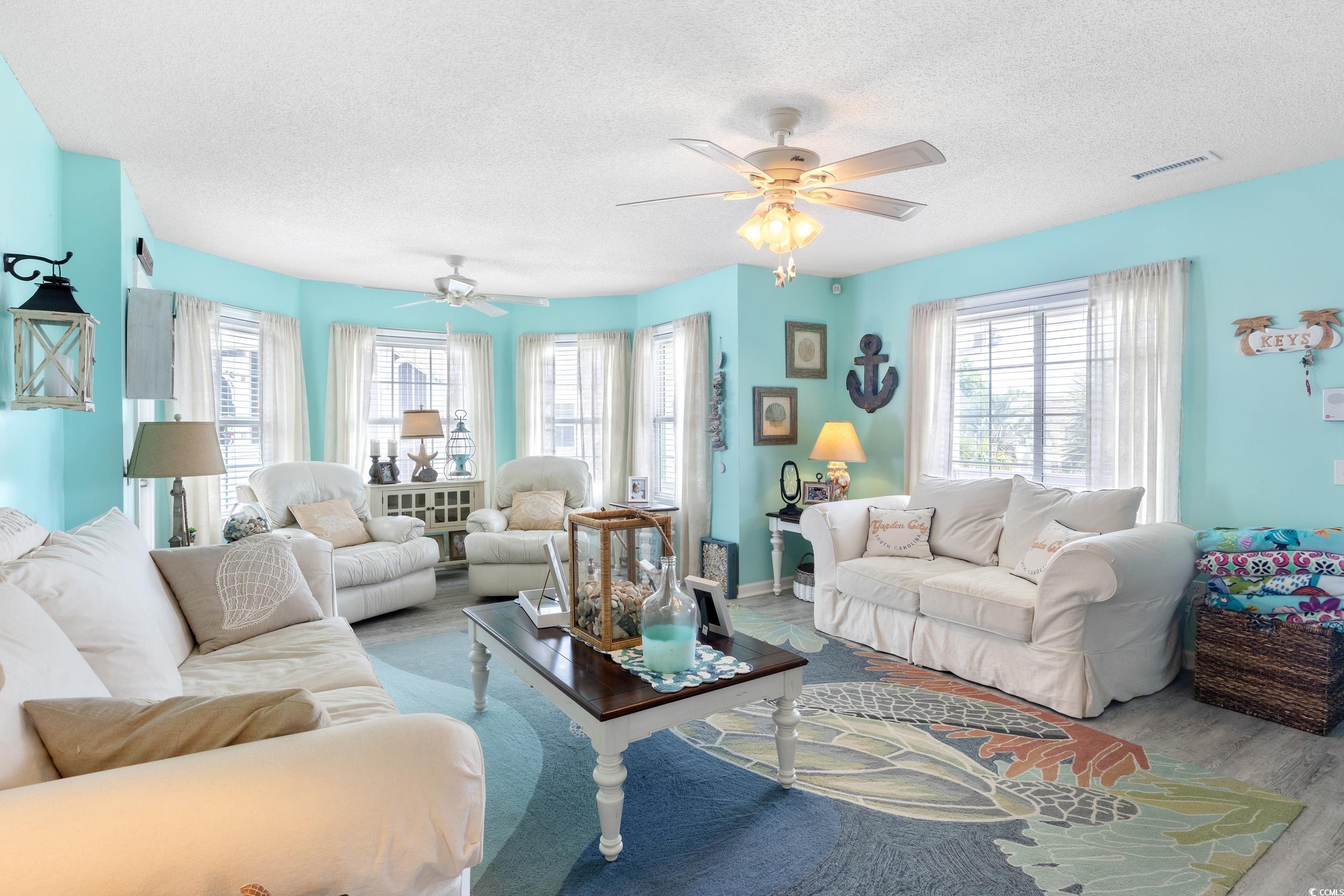 919 Dock Place Murrells Inlet, SC 29576 - Photo 8 of 39 Living area with a textured ceiling, healthy amount of natural light, wood finished floors, and a ceiling fan