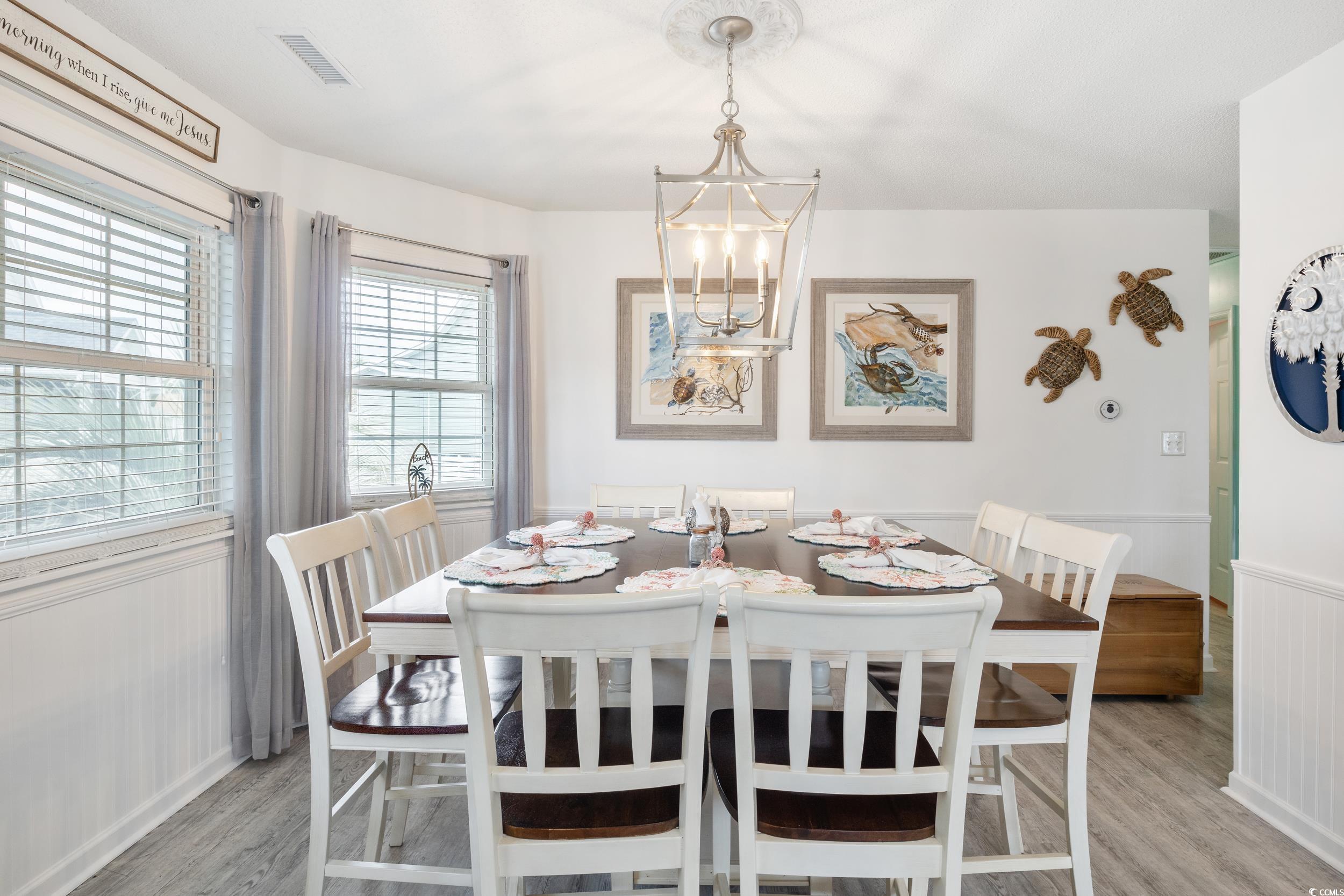 919 Dock Place Murrells Inlet, SC 29576 - Photo 10 of 39 Dining room featuring light wood-style flooring, a chandelier, and wainscoting
