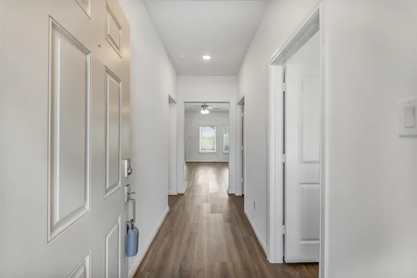 a view of a hallway with wooden floor and closet area