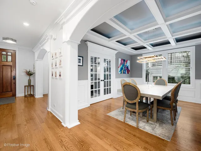 a dining room with furniture a rug a potted plant and wooden floor