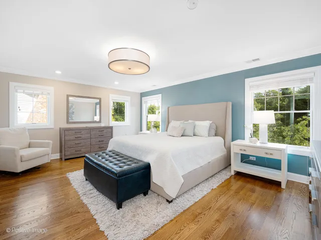 a spacious bedroom with a bed and wooden floor