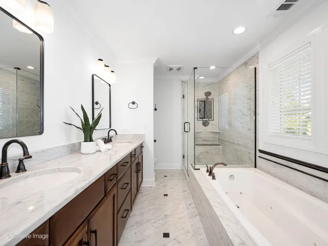 a bathroom with a double vanity sink a mirror a bathtub and shower