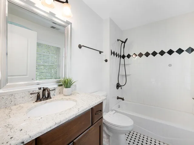 a bathroom with a granite countertop sink a toilet and a bathtub