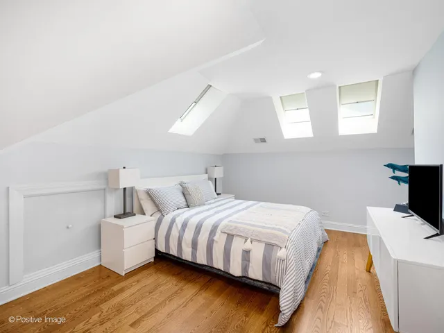 a bedroom with a bed and a flat tv screen on the dresser