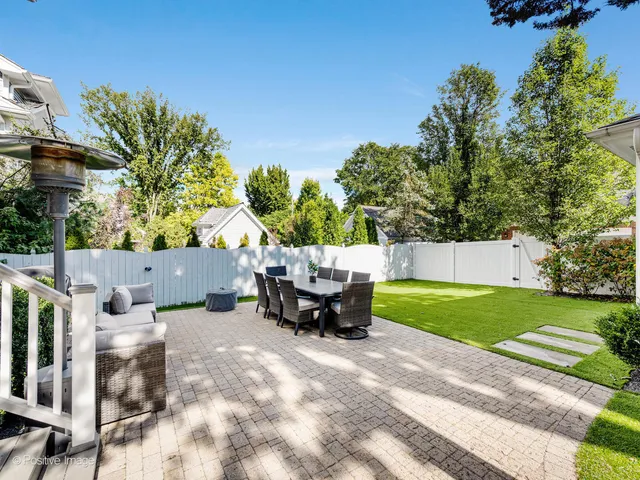 a backyard of a house with table and chairs