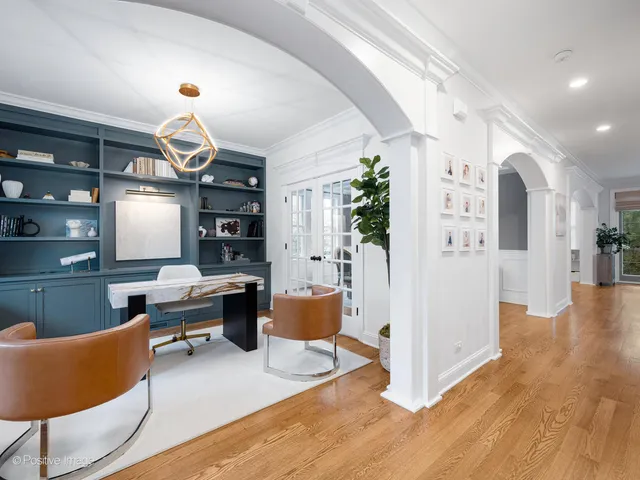 a living room with furniture kitchen view and a wooden floor
