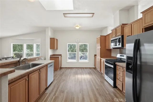a kitchen with stainless steel appliances granite countertop a sink stove and refrigerator