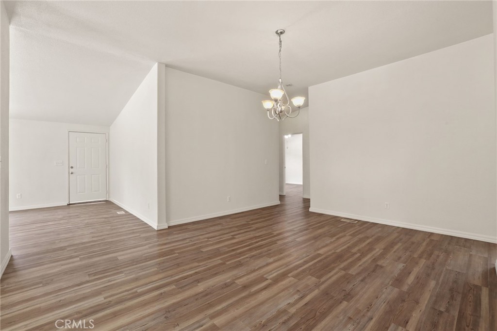 10880 Fox Springs Road Fallbrook, CA 92028 - Photo 19 of 39 a view of an empty room with wooden floor and chandelier
