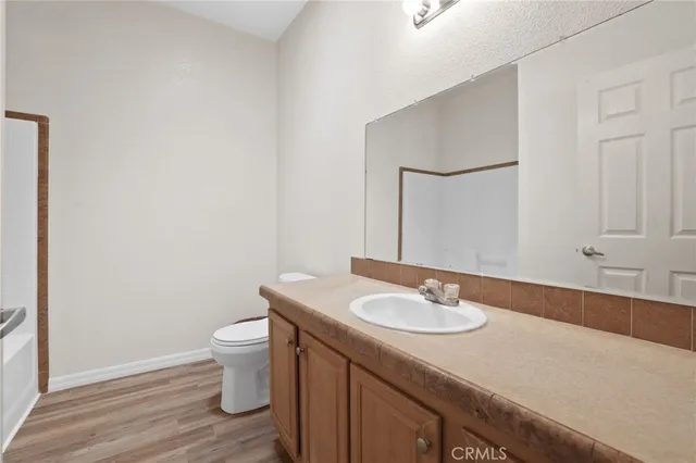 a bathroom with a granite countertop sink a toilet and a mirror