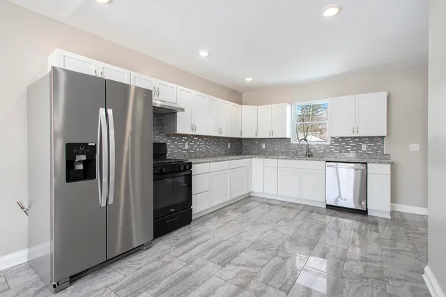a kitchen with stainless steel appliances granite countertop a refrigerator sink and cabinets