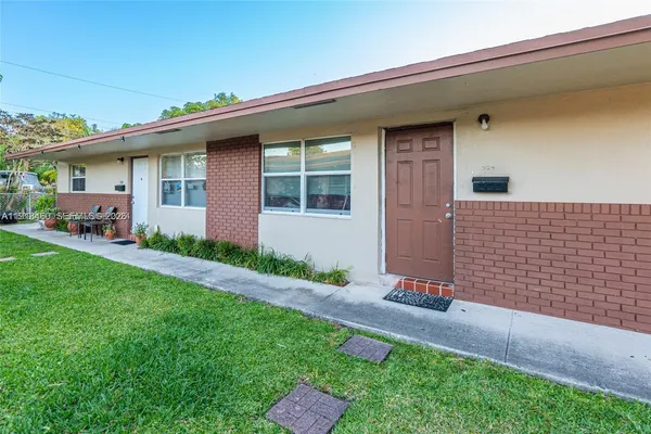 a front view of a house with a garden and plants
