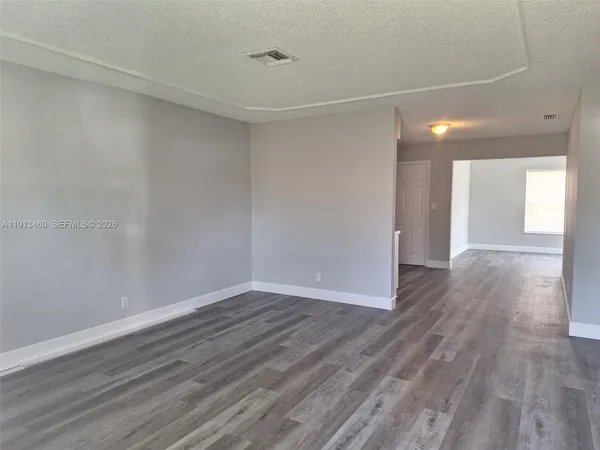 a view of an empty room with wooden floor