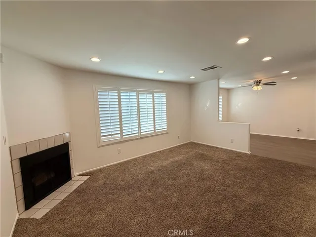 a view of an empty room with a window and fireplace