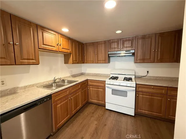 a kitchen with stainless steel appliances granite countertop a sink stove and cabinets