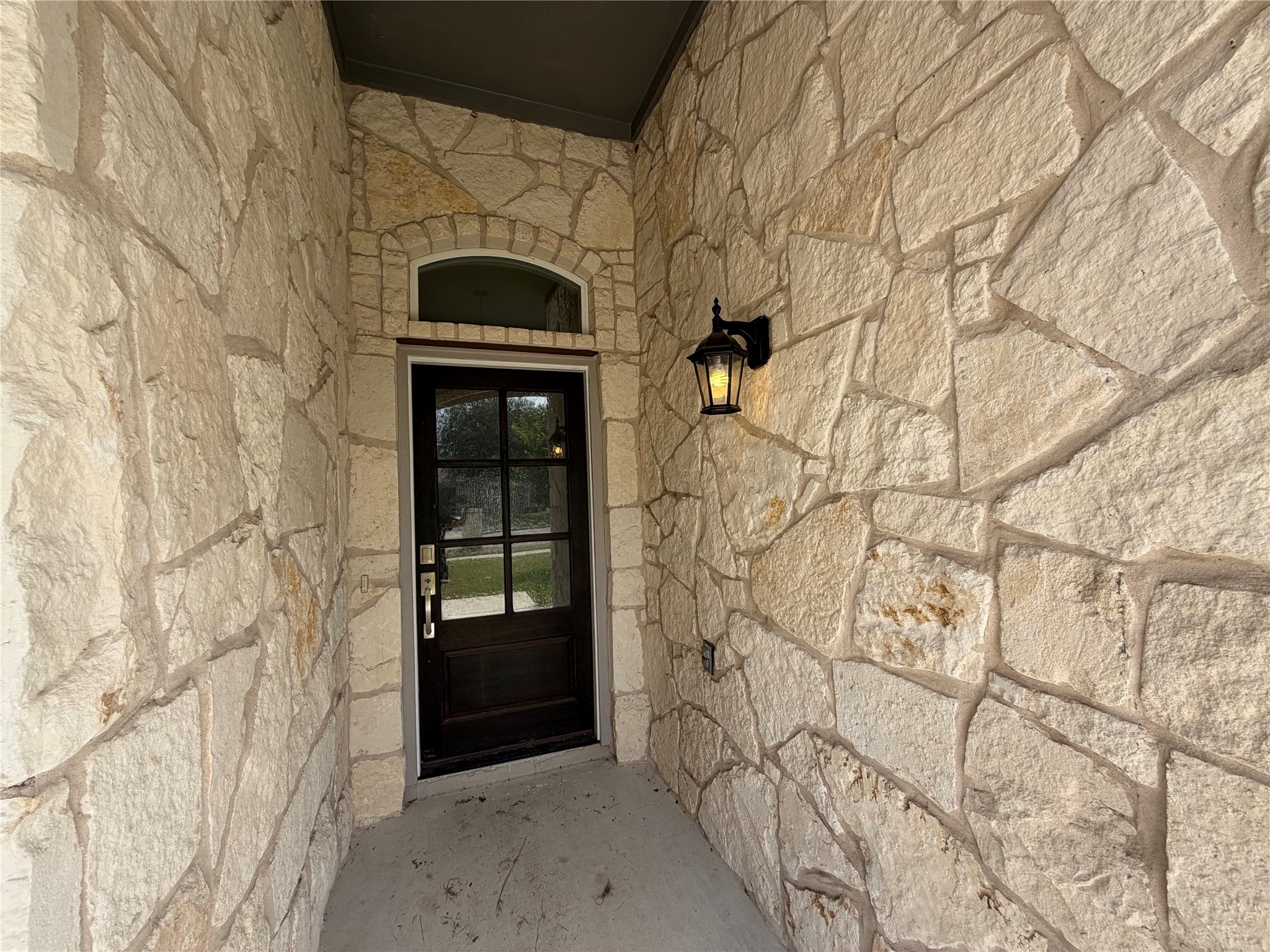 419 Gettysburg Loop Elgin, TX 78621 - Photo 2 of 21 A dark wood front door is framed by inviting natural stone, hinting at quality craftsmanship.