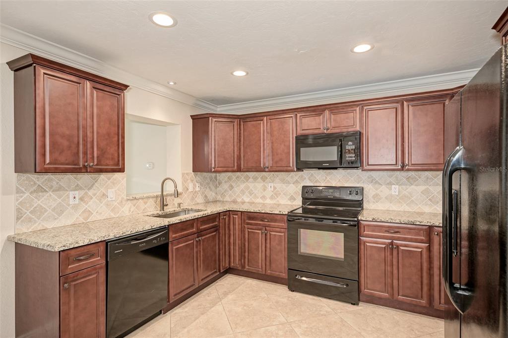 1330 Georgetowne Circle Sarasota, FL 34232 - Photo 12 of 46 a kitchen with a sink stove top oven and refrigerator