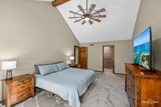 a bedroom with a bed and a flat tv screen on dresser
